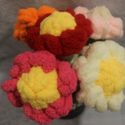 Bouquet de flores coloridas feitas de fiapos de lã sobre fundo cinza