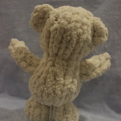 Urso de peluche bege visto de costas com textura felpuda