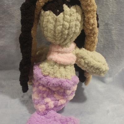 Boneca de crochê em forma de sereia em tons creme, castanho e pastel