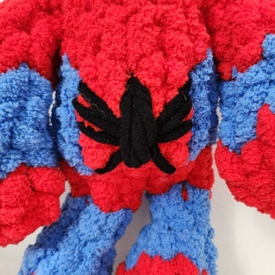 Peluche felpudo vermelho e azul com aranha preta no peito