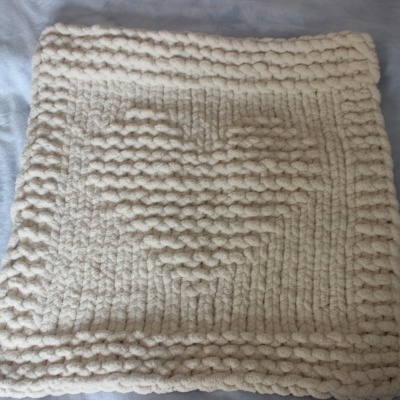 Cobertor ou manta quadrada tricotada à mão creme sobre tecido azul claro