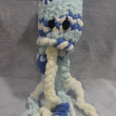 Boneco de pelúcia em forma de polvo azul, branco e azul claro com olhos pretos