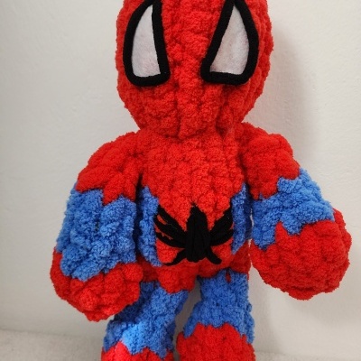 Boneco de pelúcia de super-herói vermelho e azul com olhos brancos e aranha preta no peito