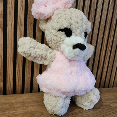 Pelúcia de urso cor de creme com vestido rosa claro e lacinho