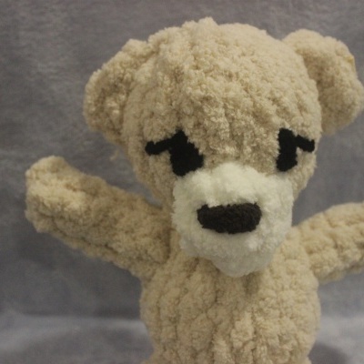 Urso de peluche bege claro com olhos pretos e focinho branco