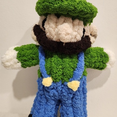 Boneco de pelúcia felpudo com roupa verde e azul