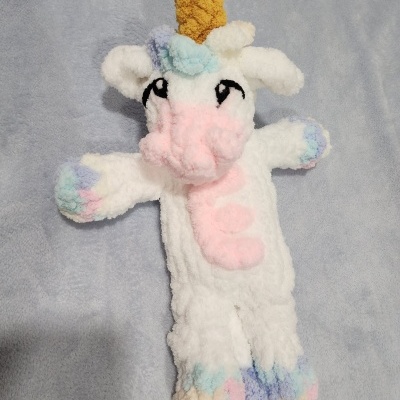 Luvas de lã felpuda com padrão de unicórnio colorido em fundo cinzento.