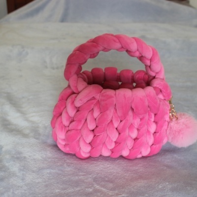 Mala rosa trançada com pompom cor de rosa