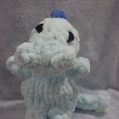 Boneco de tricot azul claro e cinzento com textura e olhos pretos