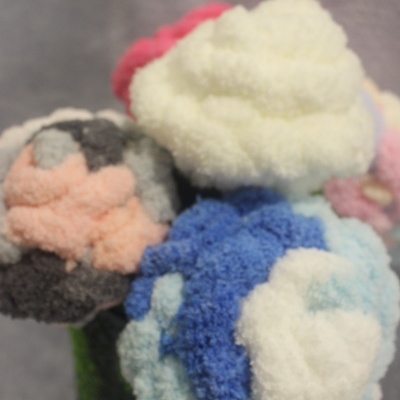 Arranjo colorido de flores feitas de pompons de lã