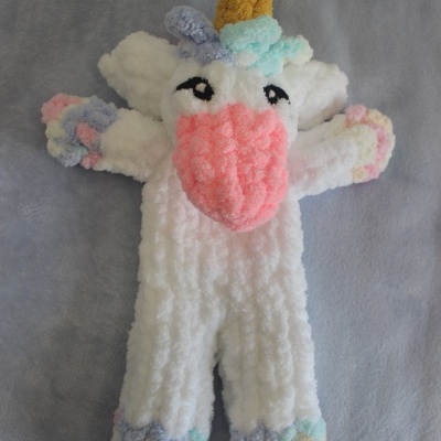 Peluche de unicórnio branco com detalhes coloridos e chifre amarelo