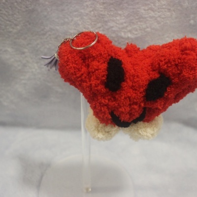 Chaveiro pelúcia vermelho em forma de coração com rosto sorridente