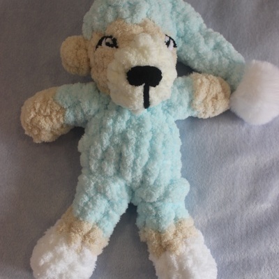 Boneco de peluche macio azul claro com detalhes bege e branco, com gorro azul claro e pompom branco