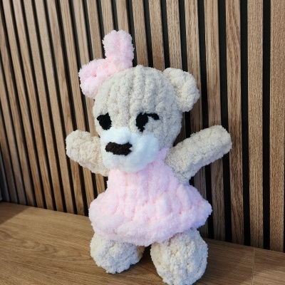 Ursinho de peluche bege claro com vestido cor-de-rosa e laço