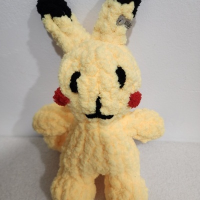 Pelúcia amarela felpuda parecida com Pikachu com orelhas pretas e bochechas vermelhas