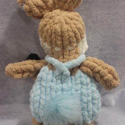 Peluche castanho e azul claro visto de costas