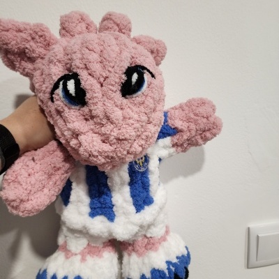 Pelúcia rosa com olhos bordados e roupa às riscas azul e branca