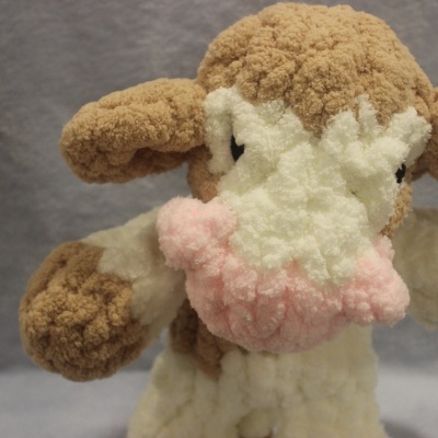 Pelúcia macia em forma de vaca com textura felpuda e cores branco e castanho claro