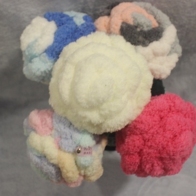 Pompons de lã coloridos sobre fundo cinza