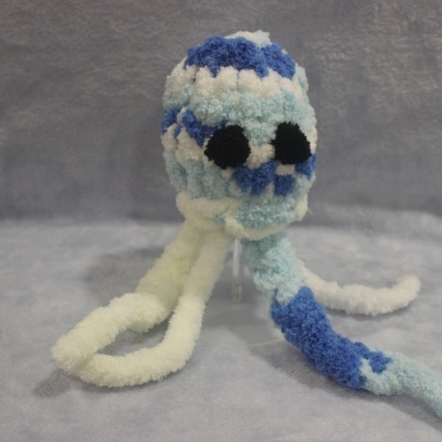 Pelúcia artesanal azul e branca em forma de polvo com olhos pretos grande