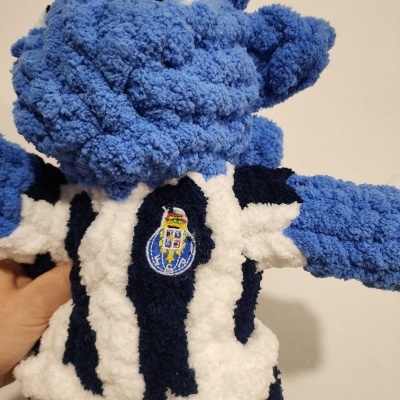 Pelúcia azul felpuda usando camisola às riscas com emblema bordado