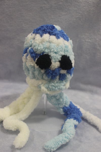 Boneco de polvo de tecido peludo azul e branco com olhos pretos