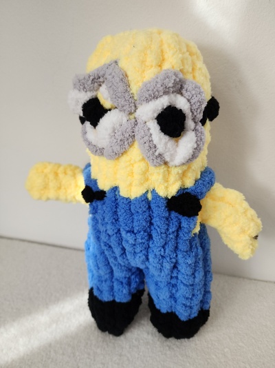 Pelúcia artesanal tipo Minion em tecido felpudo amarelo e azul.