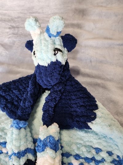 Pelúcia azul e branca em forma de girafa com padrão texturizado