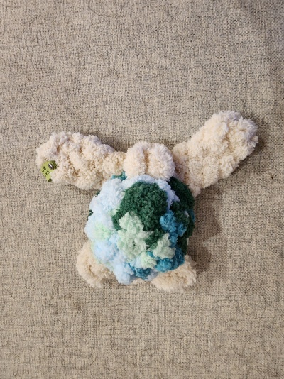 Peluche colorido de pompons e tecido bege de fundo