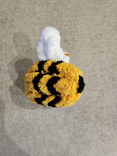 Gorro de malha amarelo com riscas pretas e topo branco com etiqueta.