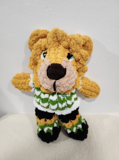 Ursinho de peluche amigurumi colorido com roupa verde e branca