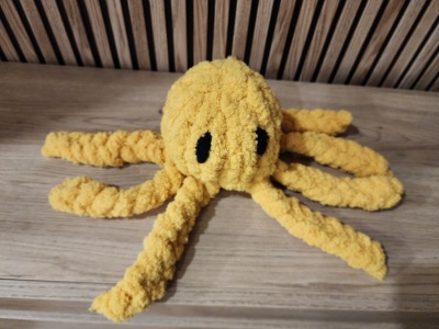 Pelúcia de polvo amarelo sobre mesa de madeira.