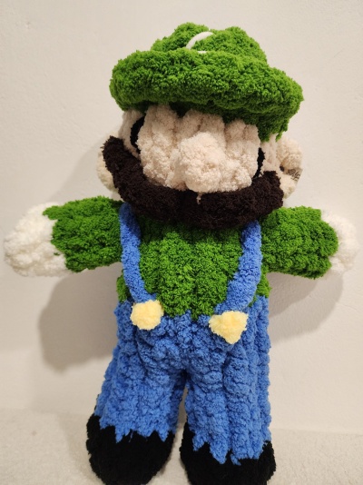 Boneco de pelúcia felpudo com roupa verde e azul