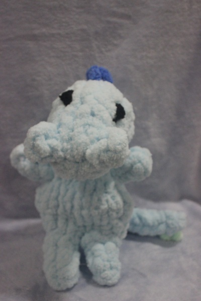 Boneco de tricot azul claro e cinzento com textura e olhos pretos