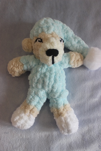 Boneco de peluche macio azul claro com detalhes bege e branco, com gorro azul claro e pompom branco