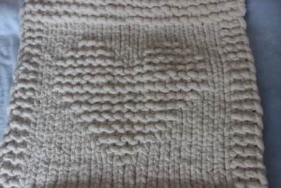 Tapete de tecido chenille creme com padrão em relevo, visto de perto