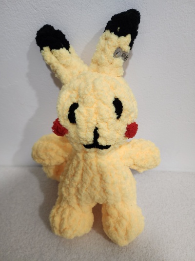 Pelúcia amarela felpuda parecida com Pikachu com orelhas pretas e bochechas vermelhas