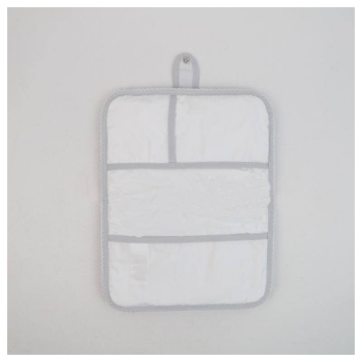 Organizador de tecido branco com três bolsos e bordas cinzentas pendurado numa parede