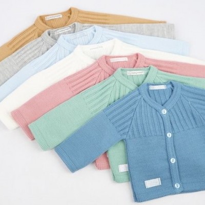 Seis casacos de malha infantil em várias cores sobre fundo branco