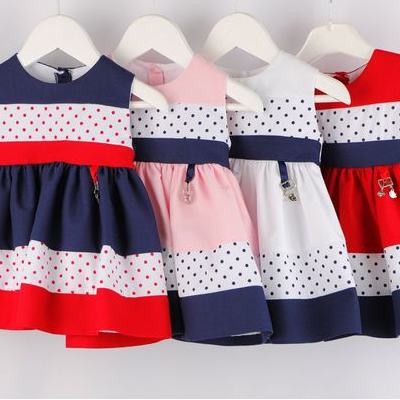 Quatro vestidos infantis coloridos com bolinhas pendurados em cabides