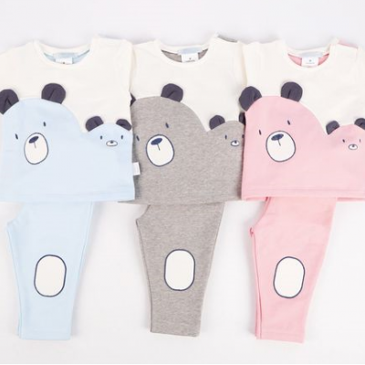 Três conjuntos de roupa de bebé com designs de ursos em azul, cinza e rosa