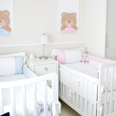 Dois berços de bebé numa decoração clara com imagens de ursos e nomes dos bebés