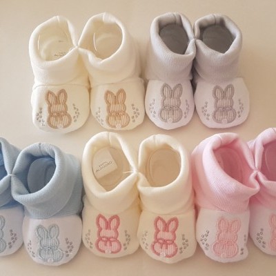 Sapatinhos de bebé em várias cores claros com orelhas bordadas.