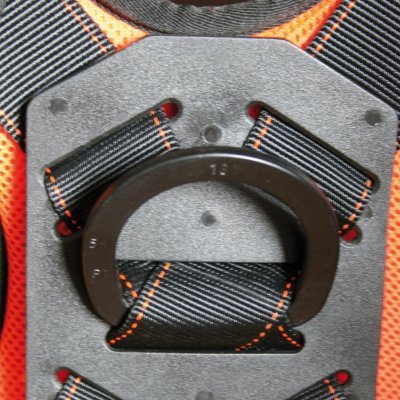 Suporte de arnês preto com costuras laranja numa base de plástico cinzento sobre fundo laranja