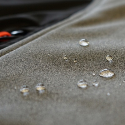 Close-up de tecido cinzento com gotas de água na superfície