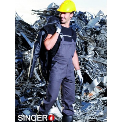 Homem com fato de macaco cinzento e capacete amarelo em frente a metal retorcido