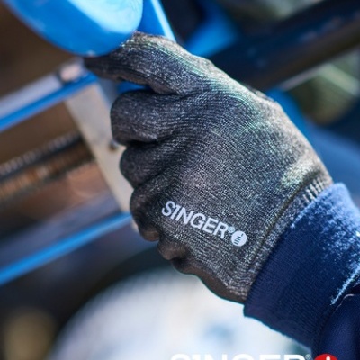 Mão com luva de segurança cinza escuro SINGER segurando peça metálica azul