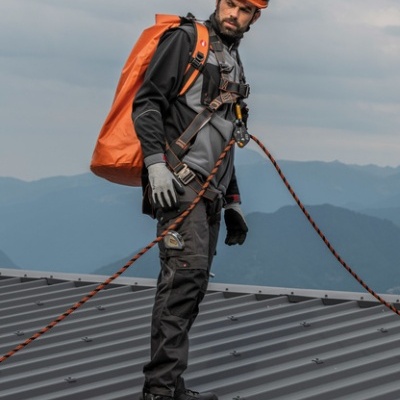 Homem com equipamento de segurança a serviço em telhado metálico