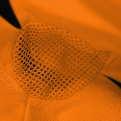 Tecido laranja com textura de malha e padrão de furos circulares
