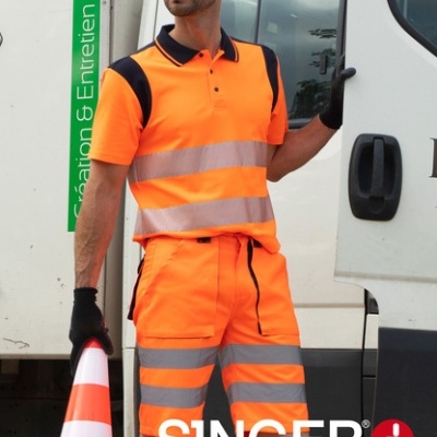 Homem com roupa de alta visibilidade laranja e cone de sinalização